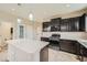 Modern kitchen with dark cabinets, stainless steel appliances, and an island at 5353 Royal Pine St, Brighton, CO 80601