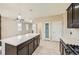 Modern kitchen with dark cabinetry, stainless steel appliances, and an island at 5353 Royal Pine St, Brighton, CO 80601