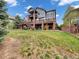 Sprawling backyard featuring a multi-tiered deck with brick supports and lush lawn at 6533 S Quemoy Way, Aurora, CO 80016