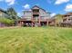 Spacious backyard with a large lawn and multi-level deck with brick support columns at 6533 S Quemoy Way, Aurora, CO 80016