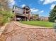 A lush backyard features an expansive lawn, tiered decks, and mature trees and landscaping at 6533 S Quemoy Way, Aurora, CO 80016