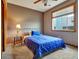 Cozy bedroom featuring a plush blue bedspread, a window with blinds, and neutral wall colors at 6533 S Quemoy Way, Aurora, CO 80016