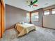 Neutral bedroom with carpet, closet, three windows, and a yellow bedspread at 6533 S Quemoy Way, Aurora, CO 80016