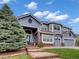 Charming two-story home featuring a well-manicured lawn, three-car garage, and brick-lined front steps at 6533 S Quemoy Way, Aurora, CO 80016