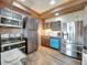 Charming kitchen featuring stainless steel appliances, painted cabinets and light wood-look flooring at 6533 S Quemoy Way, Aurora, CO 80016