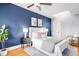 Cozy bedroom with a large bed, striking blue accent wall, a skylight, and hardwood floors at 122 N Logan St, Denver, CO 80203
