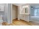 Bright bathroom features a vanity with storage, white cabinets, light countertop and opens to the main bedroom at 20 Scott Dr, Broomfield, CO 80020
