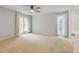 Spacious bedroom with neutral carpet, ceiling fan, and curtains framing the bright windows at 20 Scott Dr, Broomfield, CO 80020