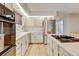 Bright eat-in kitchen features white cabinets, an island cooktop, and a stainless steel refrigerator at 20 Scott Dr, Broomfield, CO 80020