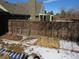 Backyard wooden fence and small garden beds filled with mulch and dried foliage at 1510 S Macon St, Aurora, CO 80012