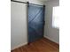 Bedroom with wood floors and a stylish sliding blue barn door at 1510 S Macon St, Aurora, CO 80012