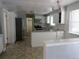 Well-lit kitchen with white cabinets, granite countertops, stainless steel appliances, and tile flooring at 1510 S Macon St, Aurora, CO 80012