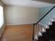 Spacious living room with hardwood floors, light-colored walls, and staircase with white banister and red carpet at 1510 S Macon St, Aurora, CO 80012