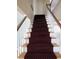 Carpeted staircase with a detailed runner, white risers and white and wood banisters at 1510 S Macon St, Aurora, CO 80012