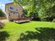 Sprawling backyard with a well-maintained lawn, wooden deck, and mature trees, offering ample space at 8772 S Carr Way, Littleton, CO 80128
