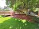 Lush backyard features a wooden deck, play equipment, mature trees, and mulch at 8772 S Carr Way, Littleton, CO 80128