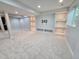 Finished basement area with carpet and shelving unit ready for a TV at 8772 S Carr Way, Littleton, CO 80128