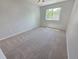 Bright bedroom featuring a window and neutral-colored carpet at 8772 S Carr Way, Littleton, CO 80128