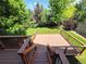 Large wooden deck with stairs offering views of the well-manicured lawn and surrounding greenery at 8772 S Carr Way, Littleton, CO 80128