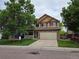 Two-story home with a stone facade, attached two-car garage, and a covered front porch at 8772 S Carr Way, Littleton, CO 80128