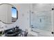 Elegant bathroom featuring a modern vanity with a vessel sink, a frameless glass shower, and marble-like tile at 10291 E 142Nd Ave, Brighton, CO 80602