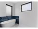 Stylish bathroom features a contemporary soaking tub with black tile surround and ample natural light from nearby windows at 10291 E 142Nd Ave, Brighton, CO 80602