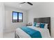 Cozy bedroom with a comfortable bed, stylish bedding, and a view of the outdoors through a large window at 10291 E 142Nd Ave, Brighton, CO 80602