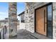 Close up on front entrance with stone pillars and a modern wooden front door with glass at 10291 E 142Nd Ave, Brighton, CO 80602