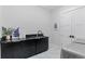 Modern laundry room with black countertop, storage, and stainless steel appliances at 10291 E 142Nd Ave, Brighton, CO 80602