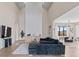 Grand living room with soaring ceilings, featuring a fireplace and seamless flow to dining area at 10291 E 142Nd Ave, Brighton, CO 80602