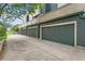 Attached garages with green doors and modern building design near landscaped street for easy parking at 9503 Longs Peak Dr, Commerce City, CO 80640