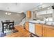 A well-lit kitchen features hardwood floors, stainless steel appliances, and an adjacent dining area with staircase access at 9503 Longs Peak Dr, Commerce City, CO 80640