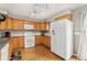 Well-maintained kitchen features wood cabinets, white appliances, hardwood floors and bright lighting at 9503 Longs Peak Dr, Commerce City, CO 80640