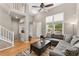 Open-concept living room has hardwood floors, a staircase, and a large window that fills the space with natural light at 9503 Longs Peak Dr, Commerce City, CO 80640