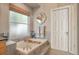 Bathroom featuring a tiled tub, a window with blinds, and neutral colors at 2533 W 110Th Ave, Westminster, CO 80234