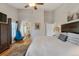 Bright main bedroom showcasing hardwood floors, a ceiling fan, and a view into the en-suite bath at 2533 W 110Th Ave, Westminster, CO 80234