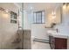 A bright bathroom features a glass shower, large mirror, modern sink, and earth-toned tile at 2233 Kearney St # 19, Denver, CO 80207