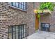View of brick apartment building entrance with awning, wood door, and security bars at 2233 Kearney St # 19, Denver, CO 80207