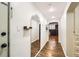 Hallway featuring wood floors, arched doorway, floating shelves, and stylish mirror at 2233 Kearney St # 19, Denver, CO 80207