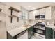 Updated kitchen featuring stainless steel appliances, white upper and dark green lower cabinets and quartz countertops at 2233 Kearney St # 19, Denver, CO 80207