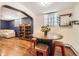 The living room features hardwood floors, a bright window, seating, and a round table with red and wood chairs at 2233 Kearney St # 19, Denver, CO 80207
