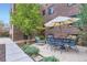 Outdoor patio has a dining table with chairs and an umbrella under a large tree at 2233 Kearney St # 19, Denver, CO 80207