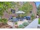 Relaxing outdoor patio area with table, chairs, grill and mature trees around brick building at 2233 Kearney St # 19, Denver, CO 80207