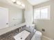 Well-lit bathroom featuring a granite-topped vanity, clean toilet, large mirror, and frosted glass window at 18945 E 45Th Ave, Denver, CO 80249