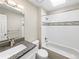 Clean bathroom featuring a shower-tub combo with a decorative backsplash and a granite-topped vanity at 18945 E 45Th Ave, Denver, CO 80249