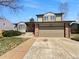 Charming two-story home featuring a brick and siding exterior with a two-car garage and manicured lawn at 18945 E 45Th Ave, Denver, CO 80249