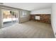 Cozy living room with brick fireplace, sliding glass doors leading to the backyard at 18945 E 45Th Ave, Denver, CO 80249