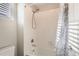 This bathroom features a shower and tub combo, with white tiled walls at 18809 E 66Th Ave, Denver, CO 80249