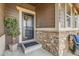 Close-up of the front porch showcases stone detailing, house number, and a decorative front door at 18809 E 66Th Ave, Denver, CO 80249