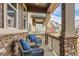 Relaxing front porch features comfortable seating, brick accents, and a view of the neighborhood at 18809 E 66Th Ave, Denver, CO 80249